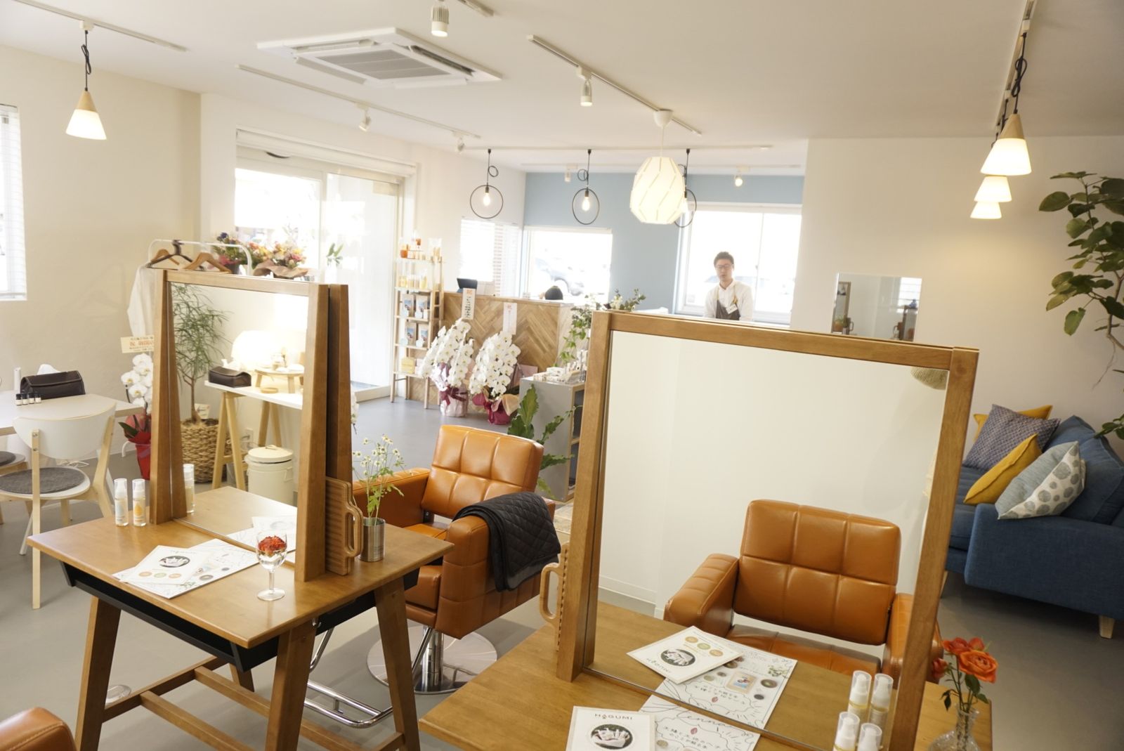 木枠の鏡とオレンジのチェアが並ぶ城東通店のカット席